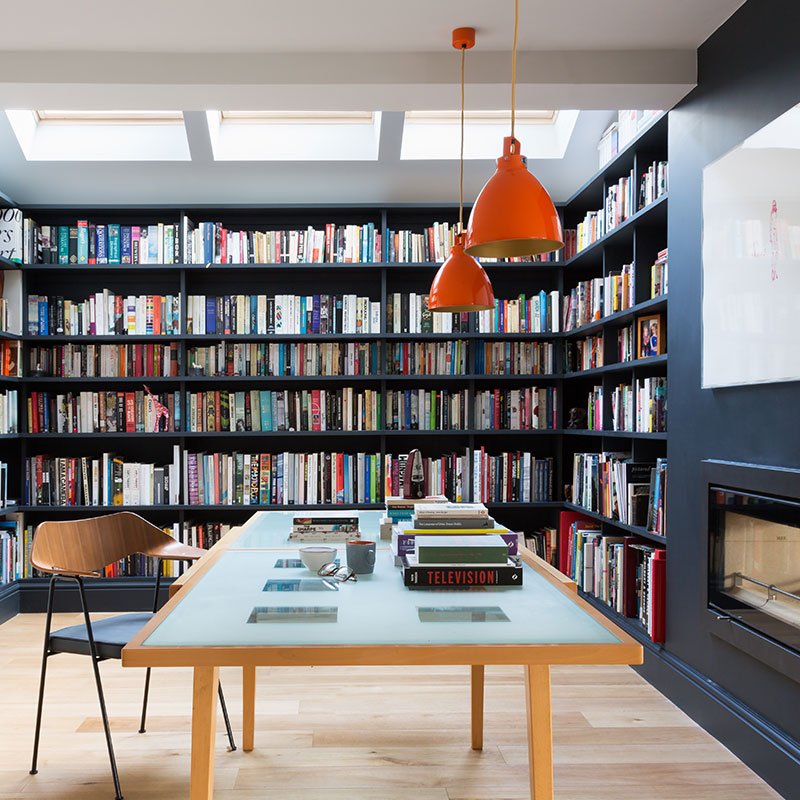Holloways of Ludlow orange Jielde pendant over mid-century desk in dark library with fireplace designed by Element Studios