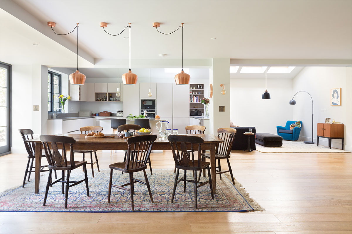 open-plan ground floor dining room and German kitchen with draped Heals copper Cohen pendants and reclaimed table and chairs