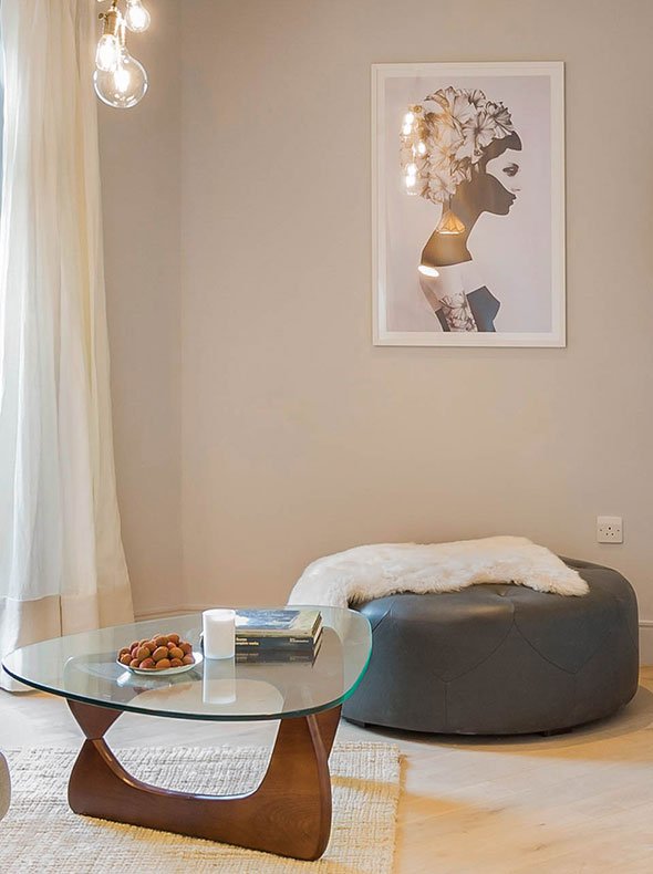 Living room Noguchi coffee table and Scott large round grey leather ottoman from Made with Marianna framed print by Juniqe