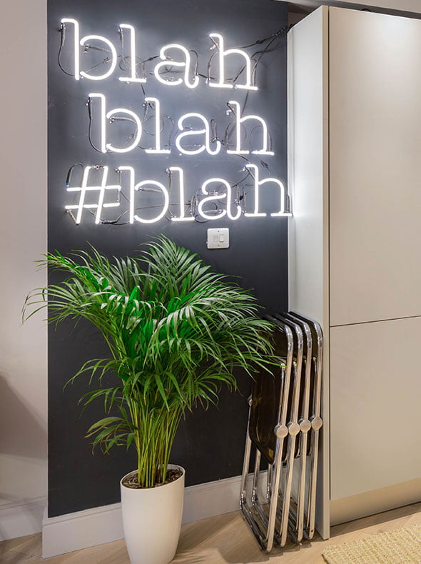 Farrow and Ball Railings painted wall with neon blah blah blah sign with green plant and Pamono vintage Castelli folding chairs