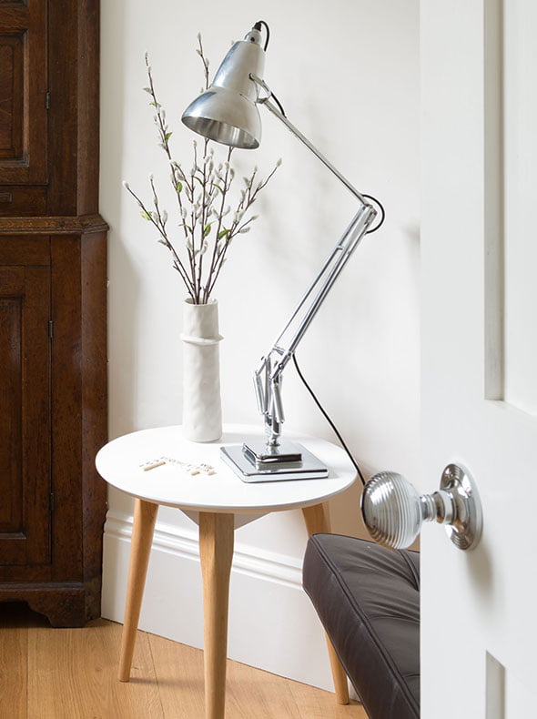 refurbished entrance hall listed building with chrome Anglepoise lamp antique cupboard and Mies van der Rohe Barcelona Chair
